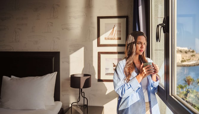 Radisson Rewards Brand - Member enjoying a drink with the room sea view